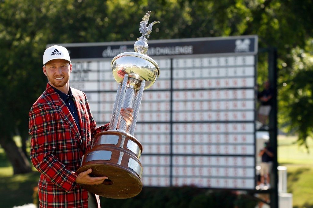 Daniel Berger hoists The Leonard Trophy, while wearing the customary plaid jacket, after winning the Charles Schwab Challenge.