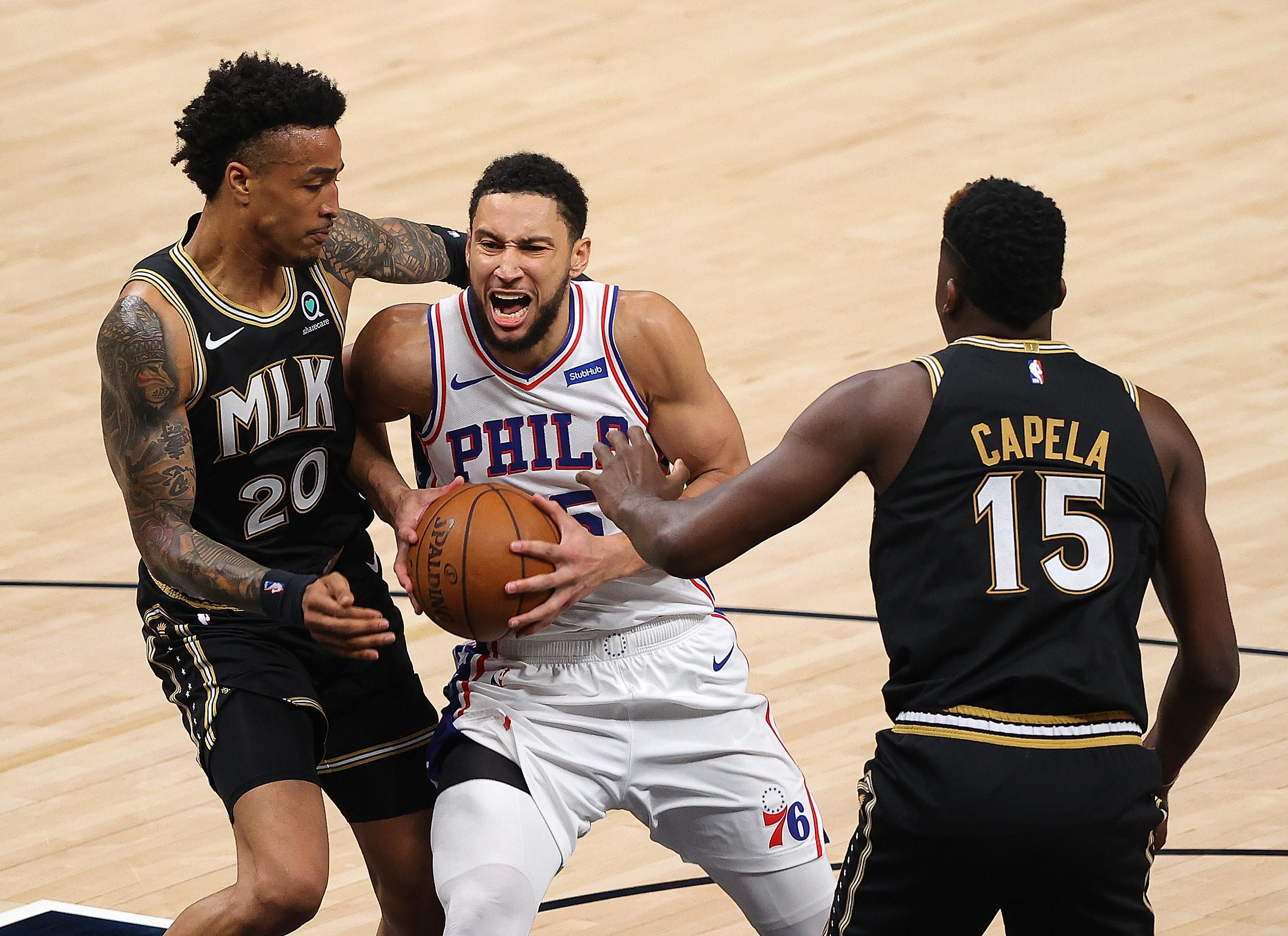 Ben Simmons of the 76ers guarded by John Collins and Clint Capela of the Atlanta Hawks