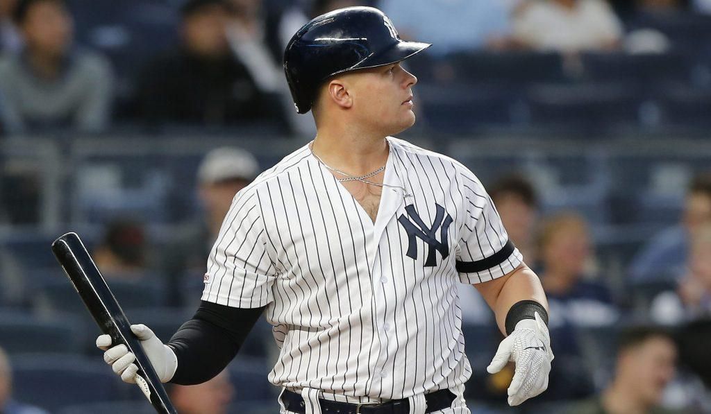 Luke Voit cradles his bat in one hand, while looking off into the distance.