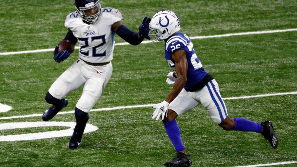 Derrick Henry stiff arms a Colts defender in the open field.