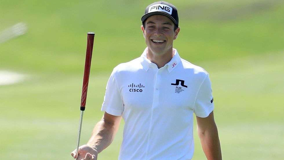 Viktor Hovland smiles after making a putt