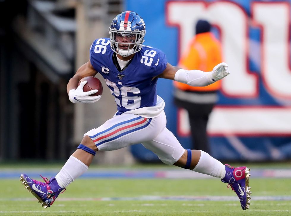 Saquon Barkley leaping with football