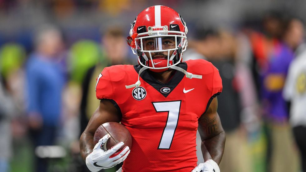 D'Andre Swift jogging with football